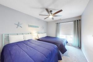 利特尔里弗Beach Golfer's Nest的一间卧室配有两张床和吊扇