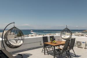 纳克索乔拉Villa Nektar, Luxury Apartment in Chora Naxos的屋顶上带桌椅的天井