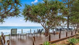 科夫斯港猫头鹰航海酒店的一个带椅子的木制甲板和海滩