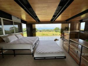 里韦拉Comfortable glamping loft with pool and vineyards的一间卧室设有两张床和大窗户