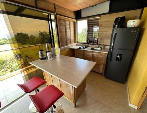 里韦拉Comfortable glamping loft with pool and vineyards的厨房配有木桌和冰箱。