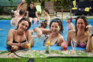 吉婆岛Cat Ba Countryside Homestay的一群坐在游泳池里喝饮料的女人
