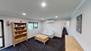 奥阿库尼5 Bedroom, Solar on Snowmass Ohakune, Yellow Door的客厅配有椅子和书架