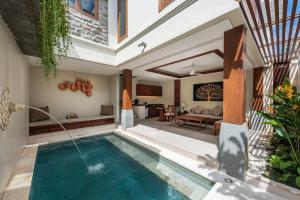 努沙杜瓦Tanadewa Villas Nusa Dua Bali by Cross Collection的别墅内的室内游泳池和客厅
