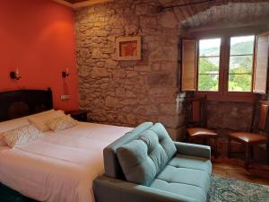OviñanaAgroturismo La Casona de Belmonte的一间卧室配有一张床和一张蓝色的沙发