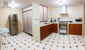 阿雷基帕SSAMANA MARÍA APARTMENT 102的一间设有棕色橱柜和瓷砖地板的大厨房