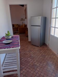 AreguáCasa de la Amistad的厨房配有桌子和冰箱