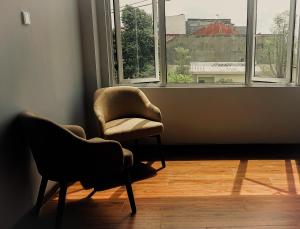 泗水AYMAN SYARIAH HOTEL的两把椅子坐在带窗户的房间