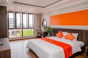 海防Sophia Hotel的一间卧室配有一张带橙色墙壁的大床
