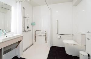 陶朗加CitySide Hotel Tauranga的白色的浴室设有水槽和卫生间。
