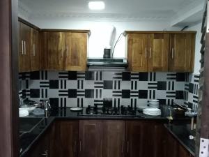 亭可马里CEYLON VILLA NILAVELI的厨房配有木制橱柜和黑白瓷砖