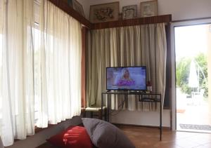 马拉松Τhe banana tree beach house的客厅配有平面电视和窗帘