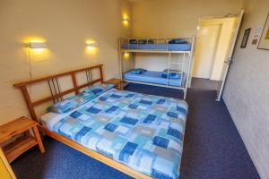 霍尔斯加普YHA Grampians Eco, Halls Gap的一间卧室配有床和双层床。