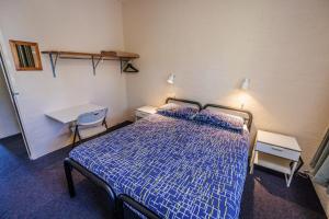 霍尔斯加普YHA Grampians Eco, Halls Gap的卧室配有1张床、1张桌子和1把椅子