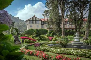 努沃勒埃利耶The Grand Hotel - Heritage Grand的一座带花园和喷泉的大房子