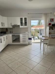 斯卡拉Dina Apartment的厨房配有白色橱柜、桌子和用餐室。