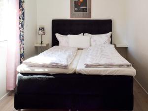 腓特烈斯塔Apartment Frederikstad II的一张黑色的床,上面有白色的床单和枕头