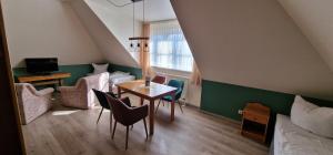 维斯马Hotel Mecklenburger Mühle Garni的一间带桌椅的房间和一间卧室