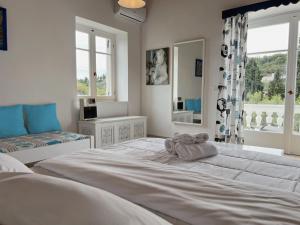 斯派赛斯Villa Ancora Spetses的白色的卧室设有一张大床和一个窗户