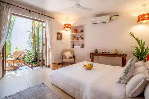 帕纳吉Nyara Fontainhas Panaji - Heritage villa Goa的卧室设有白色的床和大窗户