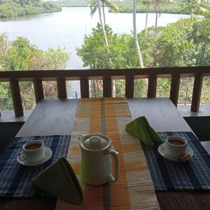 米瑞莎Atulya Lake View - Resort and Spa的阳台上的木桌和两杯咖啡