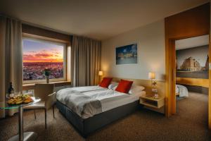 布尔诺Cosmopolitan Bobycentrum - Czech Leading Hotels的酒店客房设有一张床和一个大窗户