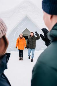 希内塔Arctic SnowHotel & Glass Igloos的一群站在雪冰屋前的人