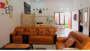 日惹Homestay Jogja Dekat Taman Pelangi by Simply Homy的一间带两张真皮沙发的客厅和一间厨房