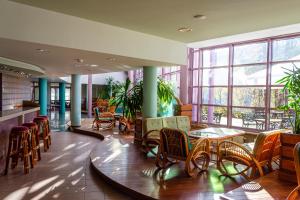 索利纳苏霖纳度假酒店&Spa中心的餐厅设有桌椅和窗户。