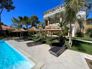 皮诺港Villa Aquamarina Pintadera Rossa的一个带遮阳伞的游泳池的度假酒店