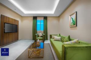 哈伊勒فندق سكناي الياسمين的客厅配有绿色沙发和电视