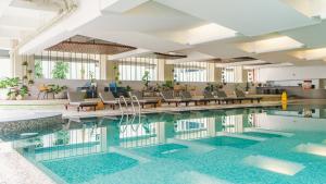 万隆Hotel Savoy Homann的一座配有桌椅的酒店游泳池