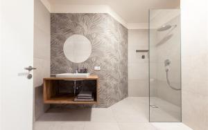 卡尔达罗Residence Hofgarten的一间带水槽和镜子的浴室