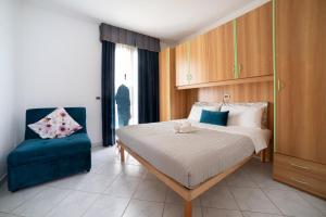 比比翁Casa Merano Residence & Ristorante Bibione Centro的一间卧室配有一张床和一张蓝色椅子