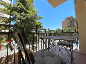 科尔多瓦Apartamento Colina B 19.的阳台配有桌椅和一棵树。