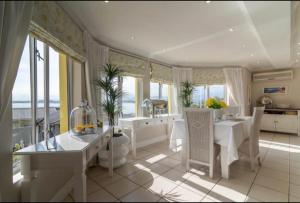 戈登湾Gordon's Beach Lodge的厨房配有白色的桌椅和窗户。