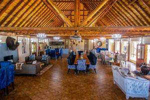 比勒陀利亚Mela Luxury Game Lodge的大楼内带桌椅的大型客房