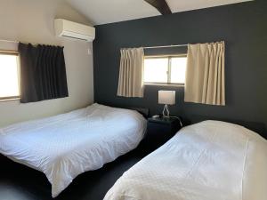京都Samurai Suite 1 , 15mins from Kyoto Eki , 5 mins to Arashiyama的一间卧室设有两张床和两个窗户。