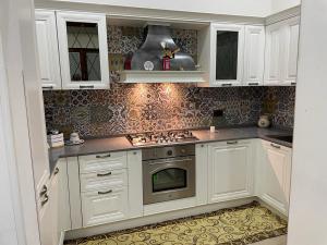 弗兰卡维拉丰塔纳Sasha House Casa Vacanze的厨房配有白色橱柜和炉灶烤箱。