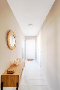 马贝拉Bella Marbella的白色走廊,配有木桌和镜子