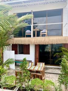 恰洛克拉姆Boho Beachfront Cottage的阳台房屋,配有两把椅子和一张桌子