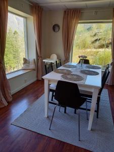 MasfjordenHoliday home - Your dream vacation awaits in Massfjorden的一间配备有白色桌椅的用餐室