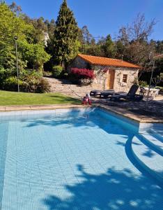 Monte CórdovaCasa dos três rapazes的一个带两把椅子的游泳池以及一座房子