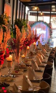 圣金HOTEL BAR RESTORANT YLLI的一张长桌,上面放着食物和鲜花