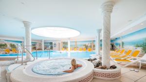 宾茨Arkona Strandhotel的 ⁇ 染一个游泳池,一个女孩在热水浴缸中