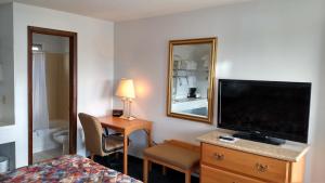科迪怀俄明酒店的酒店客房设有电视、床和书桌