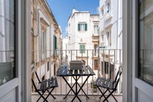 马丁纳弗兰卡Typical Apulian Apartment的阳台配有两把椅子和一张桌子