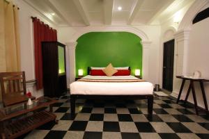 蓬蒂切里拉夏杜酒店的一间卧室配有一张带绿色墙壁的床