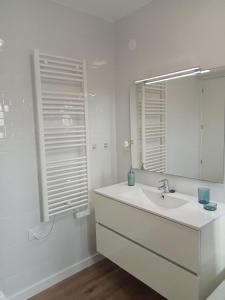 拉皮内达SEAFRONT APARTMENT PINEDA BEACH的白色的浴室设有水槽和镜子