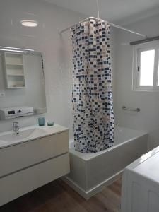 拉皮内达SEAFRONT APARTMENT PINEDA BEACH的带浴缸和淋浴帘的浴室